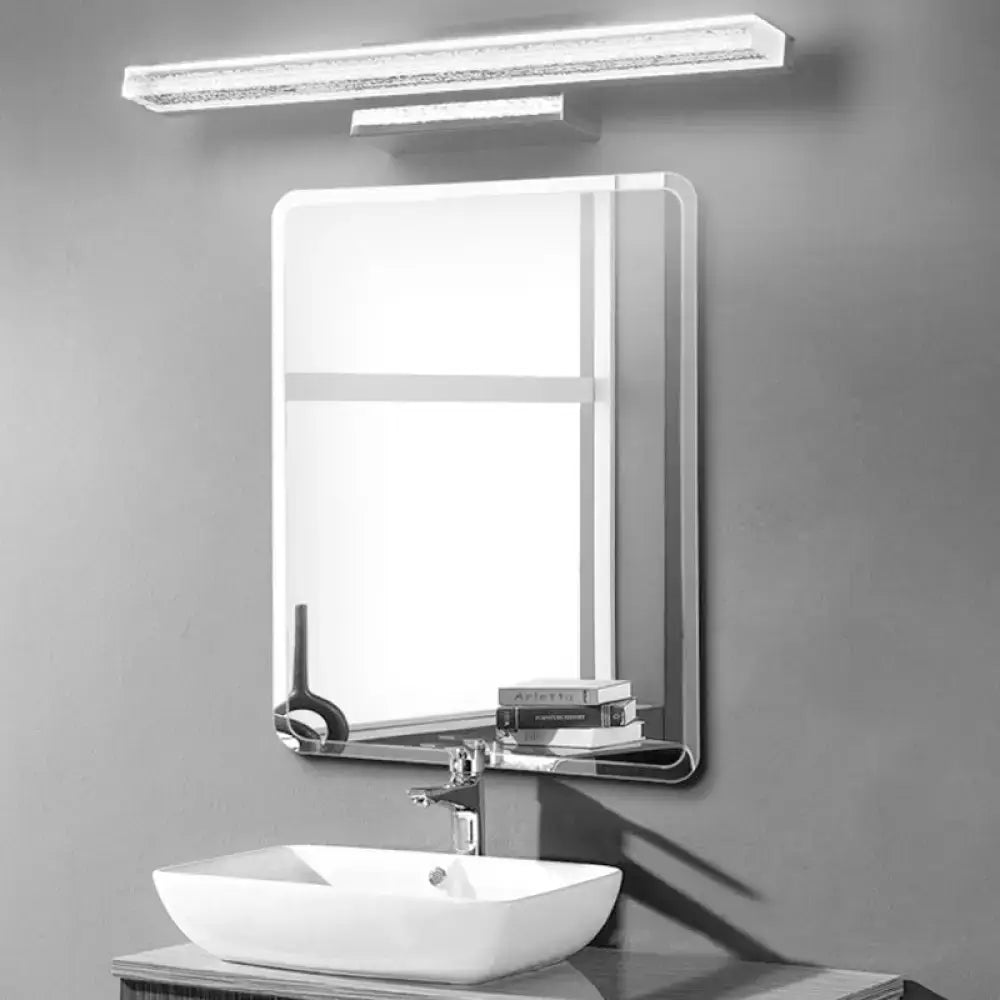 Modern rectangular bathroom mirror with sleek chrome frame and integrated shelf above white vessel sink with stainless steel led light