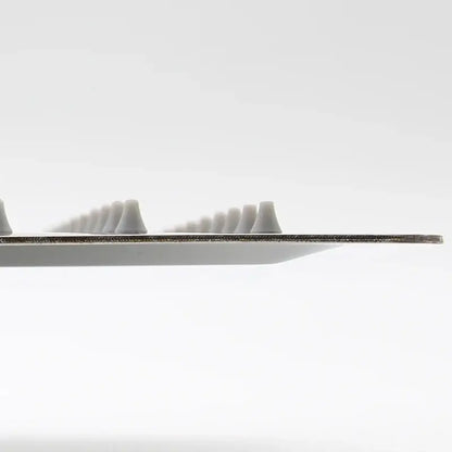 A sleek metallic-edged dental floss pick with small white tips alongside a stainless steel square ceiling rain shower head