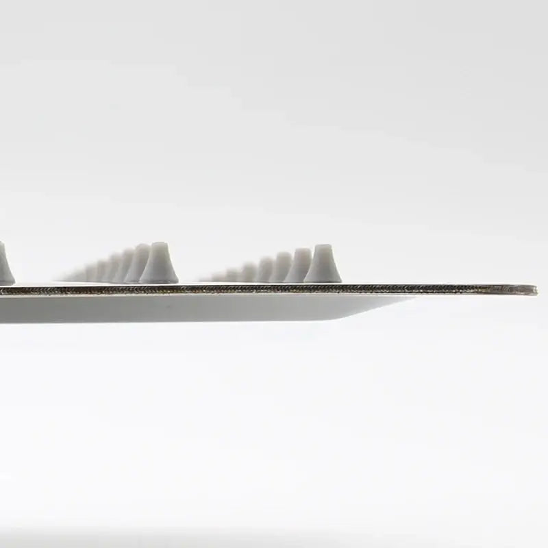 A sleek metallic-edged dental floss pick with small white tips alongside a stainless steel square ceiling rain shower head