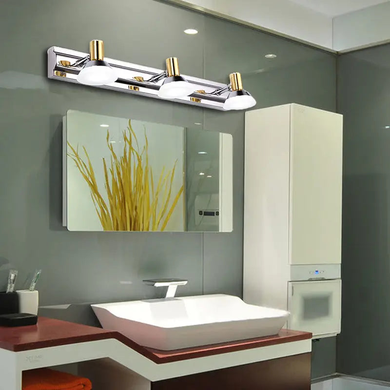 Modern stainless steel wall light with chrome finish, gold accents, and three adjustable white acrylic cone shade bulbs