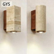 Modern stone and wood wall lamp with rectangular cave stone body and dark wood accent emitting warm light decorbites cave stone