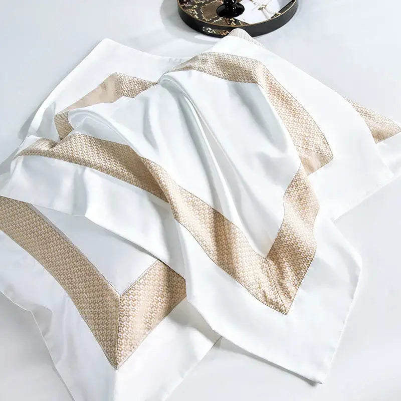 White satin pillowcase with gold toned woven border accents in modern striped white and beige king size luxury bedding set