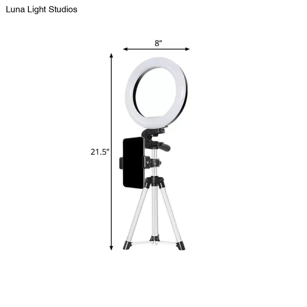 Modern style black and silver led ring flash light with 8-inch white circular light mounted on a tripod with phone clamp