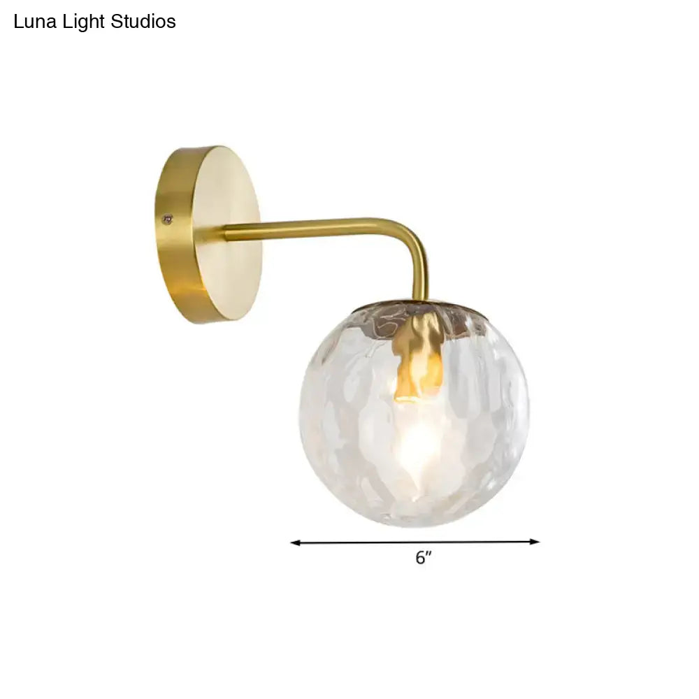 Modern style gold color wall sconce with hammered texture and clear glass globe for living room lighting