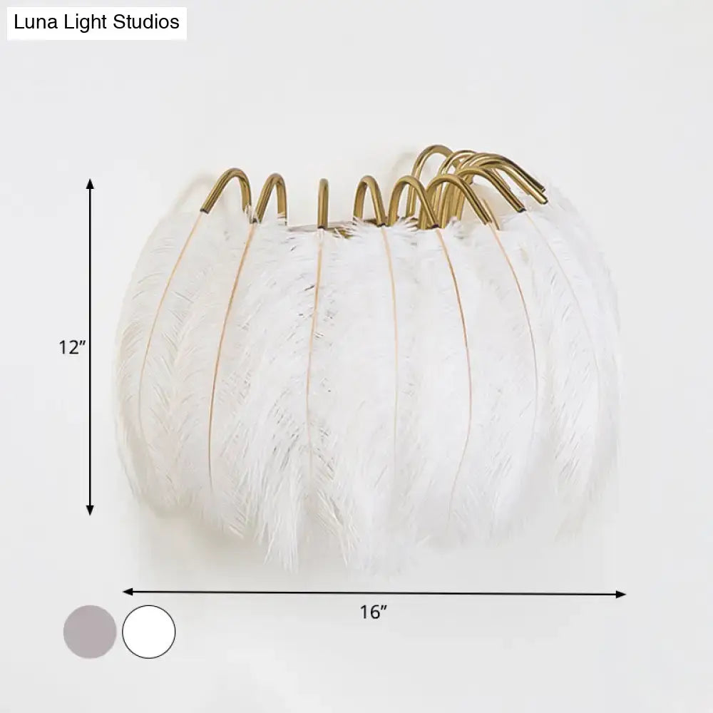 Modern style grey white sconce light featuring white feathered pumpkin design with gold toned metal hooks for wall decor
