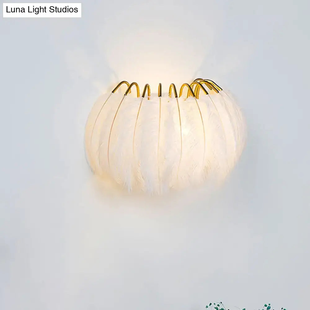 Modern style grey white feather sconce light with gold toned metal accents for elegant parlor wall decor