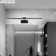 Modern style slender black led vanity light with warm white glow and compact shade height mounted above mirror