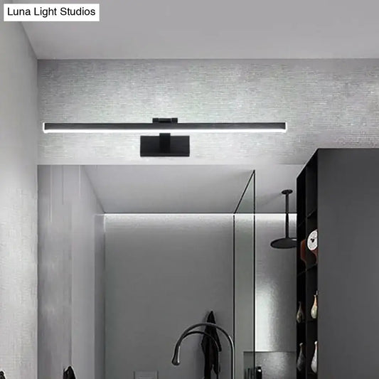 Modern style slender black led vanity light with warm white glow and compact shade height mounted above mirror