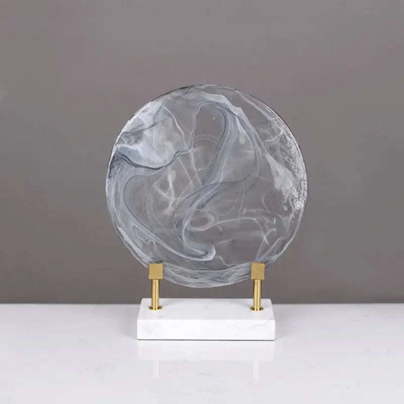 Modern swirling glass geometric disk home decor figurine in translucent gray and white marble on minimalist marble base