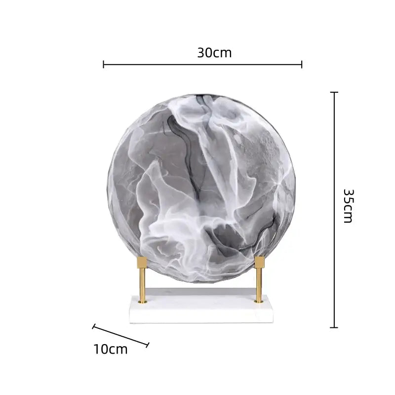 Gray and white marbled glass geometric disk figurine on minimalist gold stand for modern home decor display