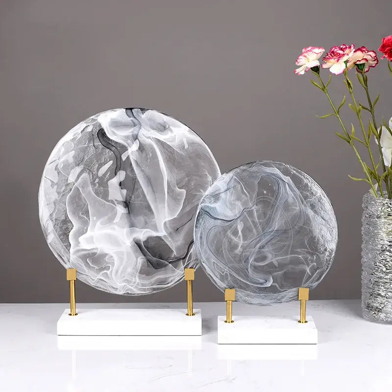Two elegant translucent marble spheres with gray and white swirls on gold stands serve as modern home decor figurines