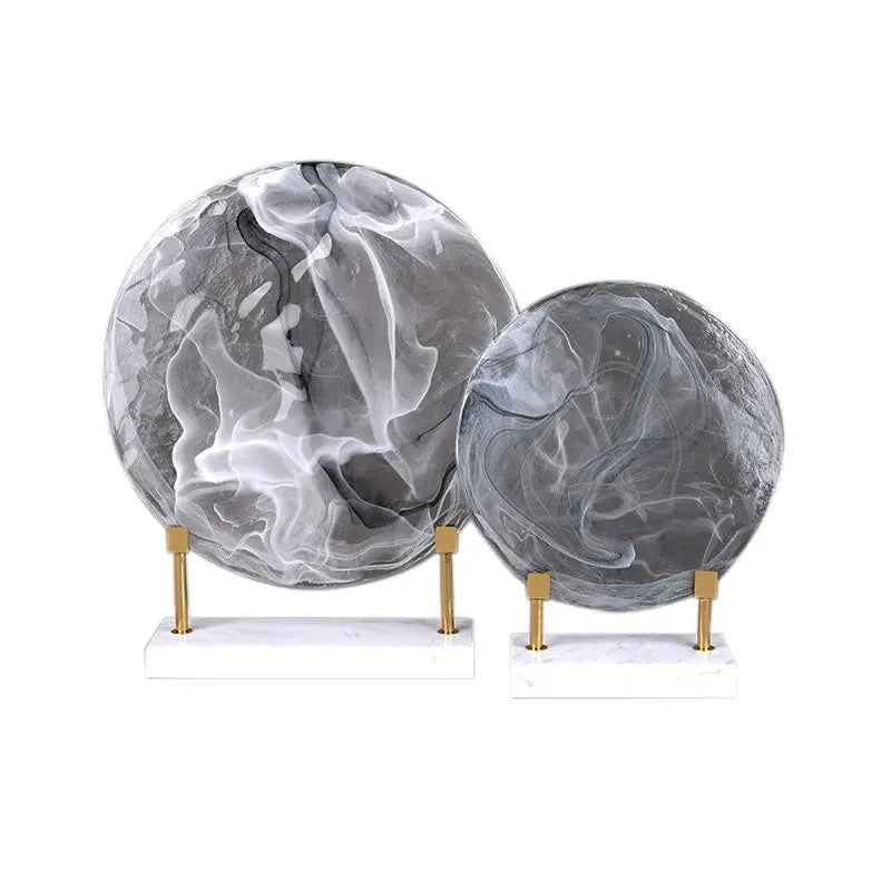 Two elegant gray and white marbled geometric disk home decor figurines on marble bases with gold-toned stands