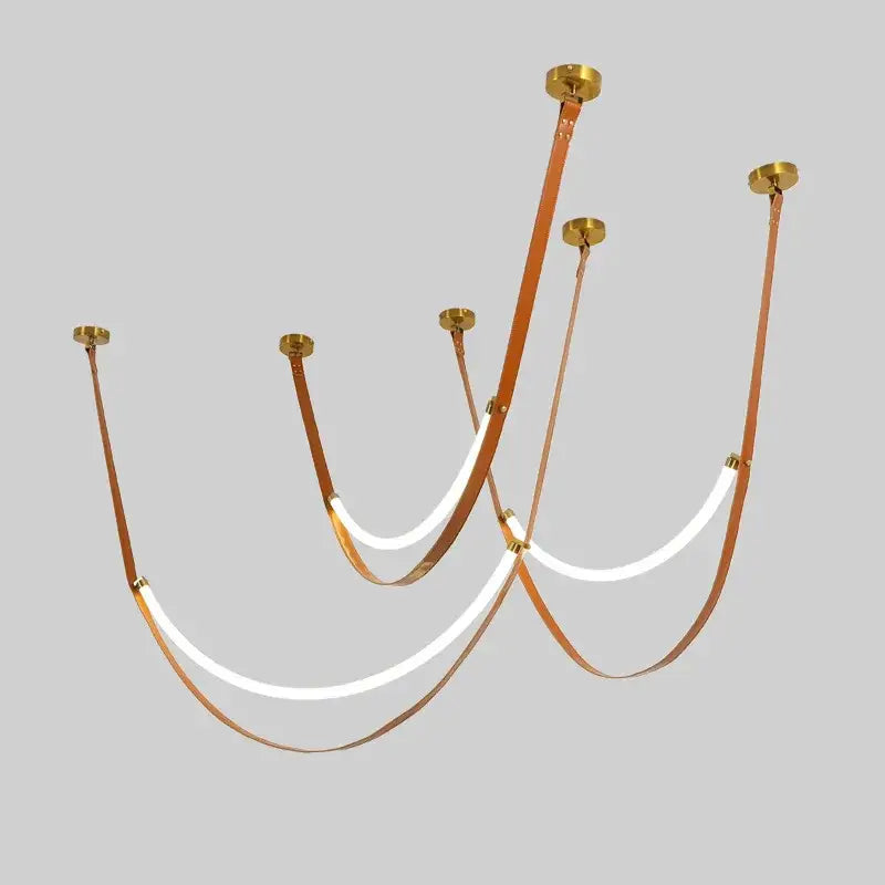 A modern tan leather and brass led tube suspension chandelier with curved straps and glowing white led tube lights