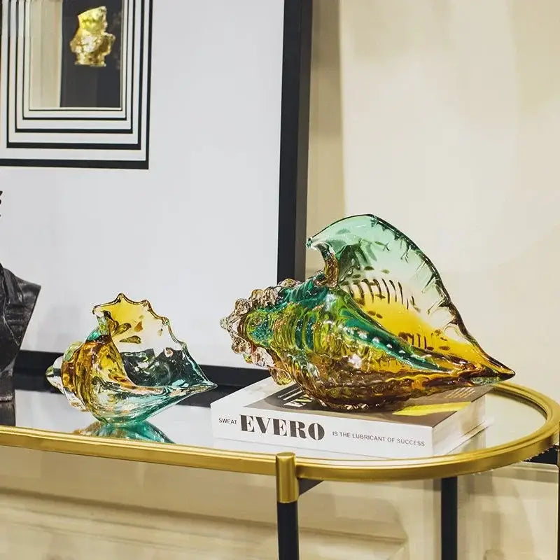 A vibrant translucent glass conch shell statue with swirling teal and amber hues for modern living room decor