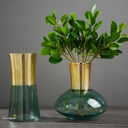 Two modern teal and amber gold metal glass vases with gold ribbed necks holding leafy plants for decorbites gold metal decor