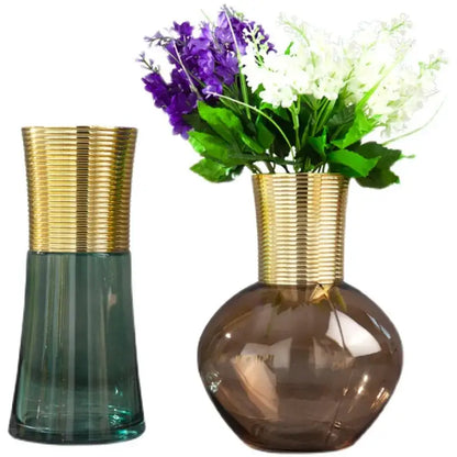 Two modern teal and amber gold metal glass vases with ribbed necks holding purple and white artificial flowers decorbites gold metal