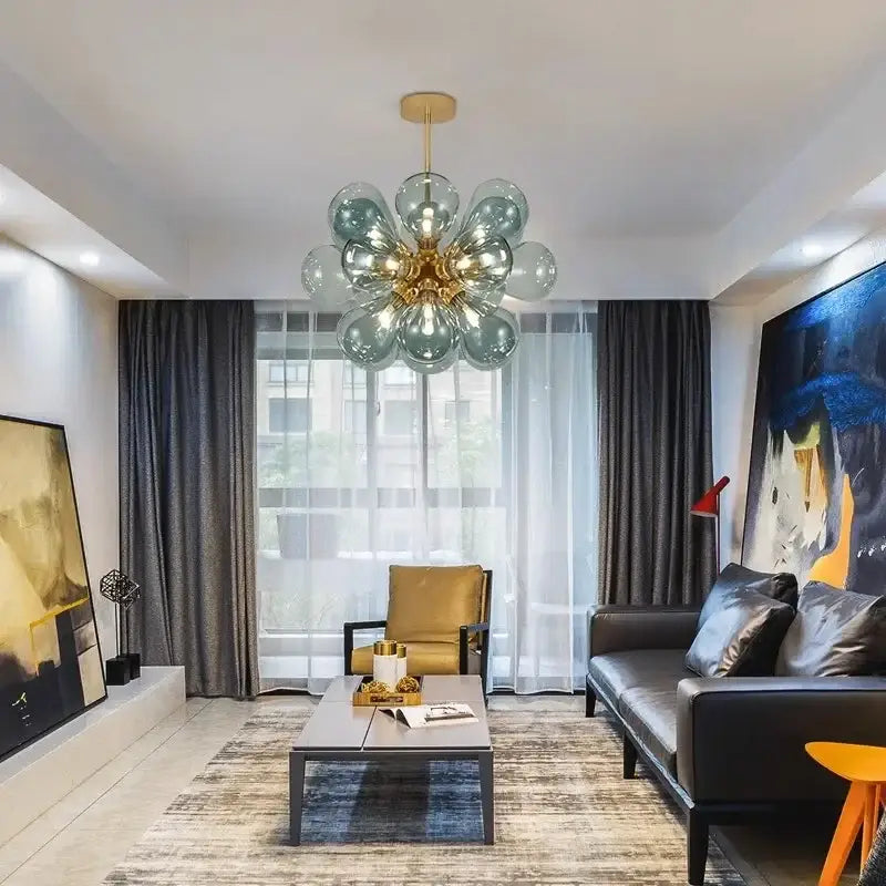 A modern glass bubble chandelier pendant light with gold-toned fixture and teal glass globes for living room decorbites