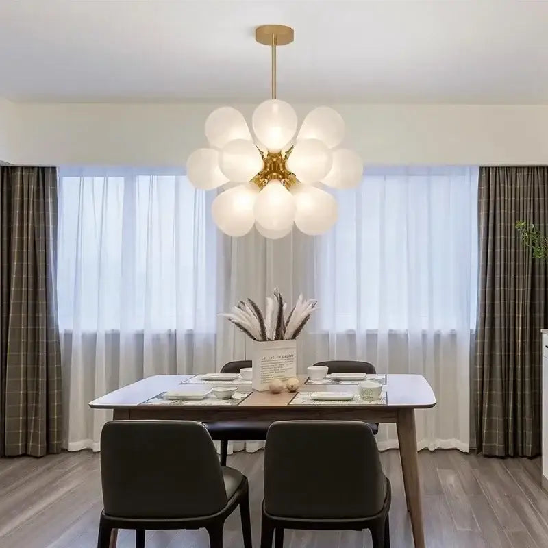 Modern teal and gold glass bubble hanging pendant light with gold-toned chandelier and frosted glass globe bulbs