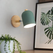 Modern teal and wood wall lamp with matte finish and natural wood base designed as a bedroom sconce