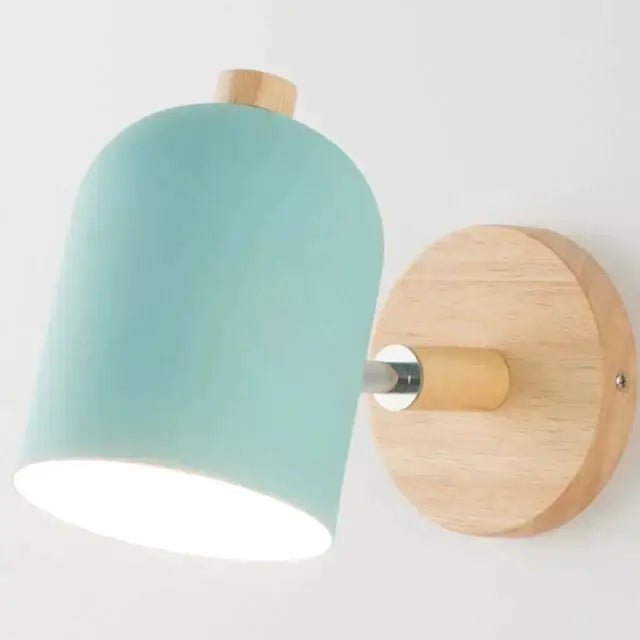 Minimalist wall lamp with a soft teal ceramic shade and natural wood accents for modern bedroom sconce lighting