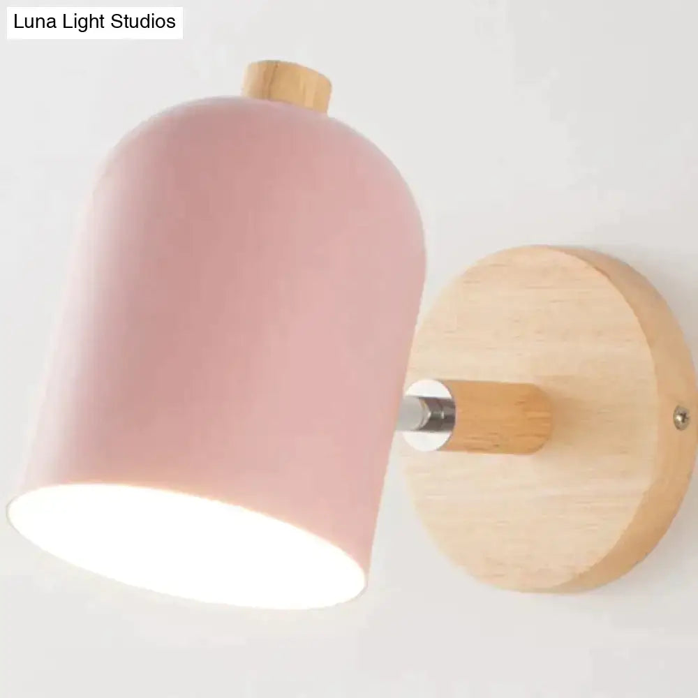 Modern teal and wood wall lamp featuring a pink matte-finished cylindrical sconce with a natural wood base