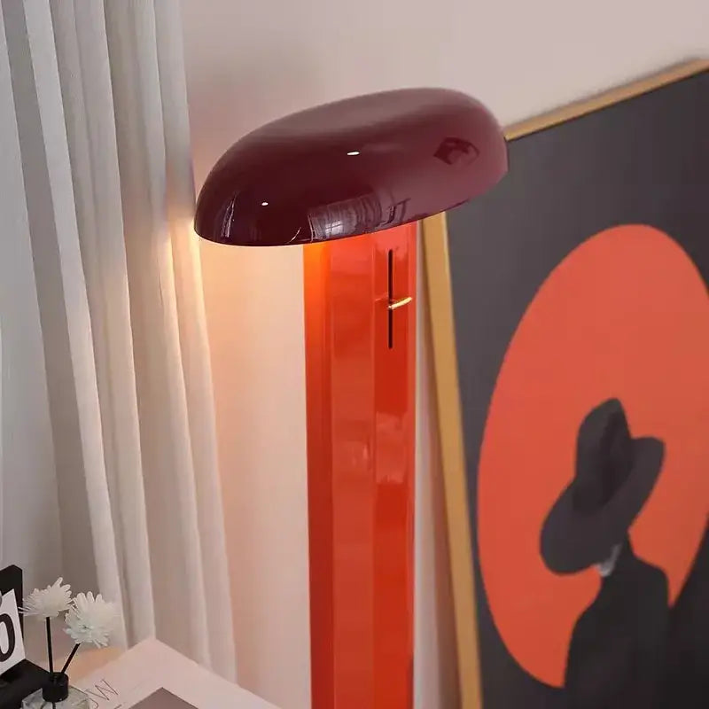 A sleek glossy burgundy decorbites designer mushroom floor lamp with a vibrant orange translucent base for living room decor
