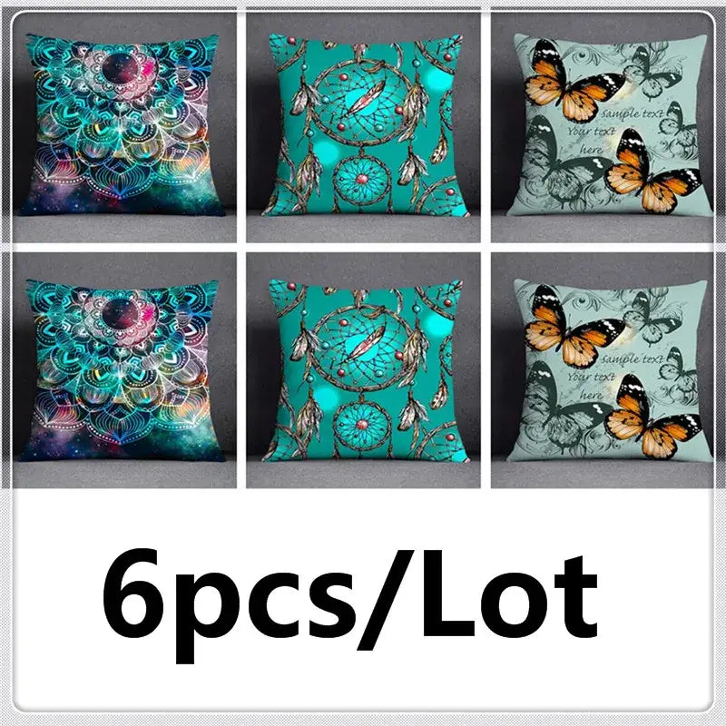 Six decorative teal throw pillows with cosmic mandala dreamcatcher and orange butterfly designs on soft fabric surface