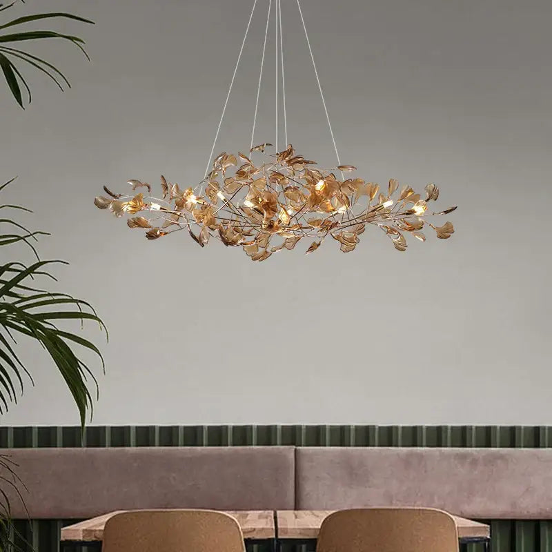 Modern teal glass gingko leaf chandelier featuring delicate golden leaf metal pieces for elegant dining room decorbites gingko design