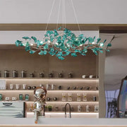 A modern teal glass gingko leaf chandelier with integrated lighting for dining room decorbites gingko leaf decor