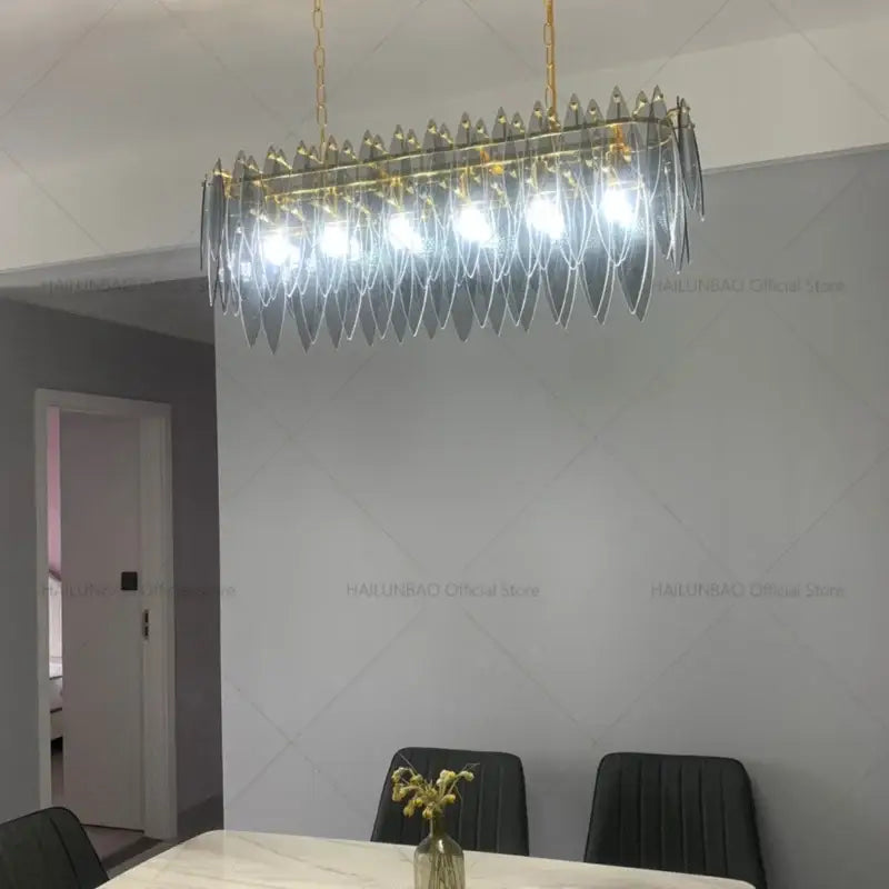 Modern teal and gold glass chandelier light with cascading translucent glass leaves for living room decor