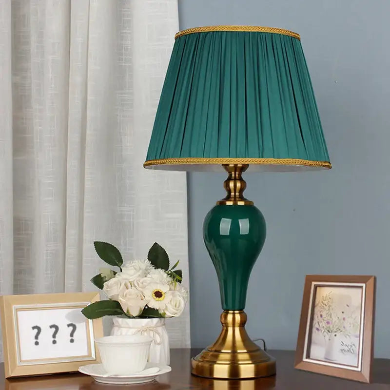 Modern teal green ceramic table lamp with gold-toned metal base and trim for bedroom and living room use