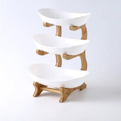 Modern teal and white ceramic layer table plates in a three-tiered white ceramic bowl stand with bamboo frame for dining use