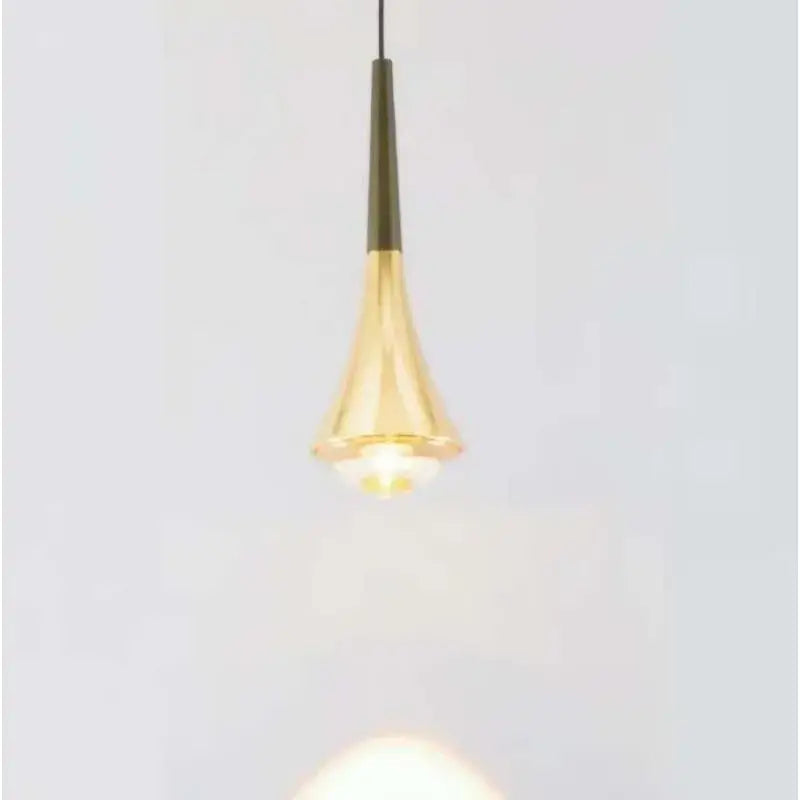 A sleek golden brass conical cord pendant light with a smooth reflective surface for modern dining rooms