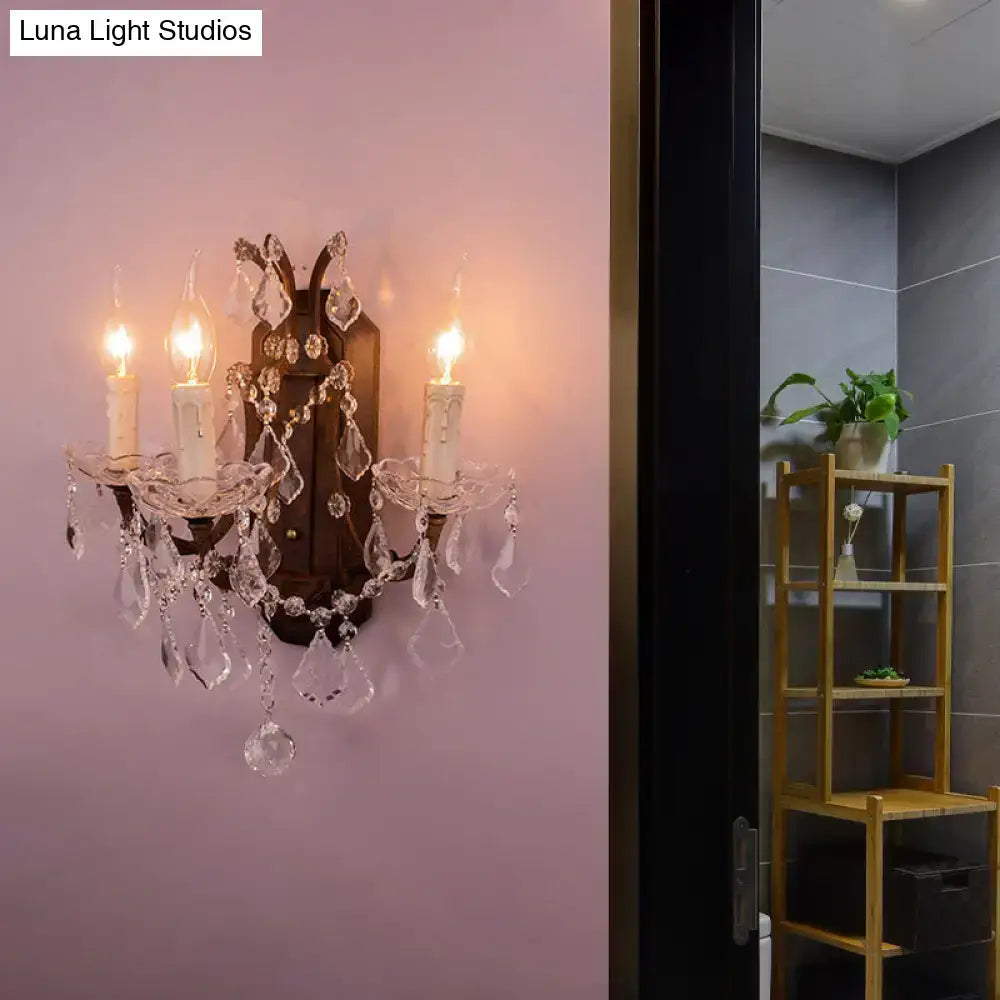 Elegant modern teardrop crystal wall lamp with white and rust finish featuring three candle-like bulbs and glass droplets