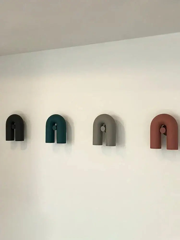Four minimalist u-shaped wall hooks in matte black teal gray and terracotta for modern led u-shaped wall lamp use