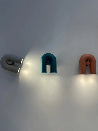 Three modern u-shaped wall lamps in matte gray, teal, and terracotta finish for living room led lighting