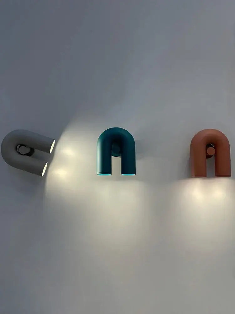 Three modern u-shaped wall lamps in matte gray, teal, and terracotta finish for living room led lighting