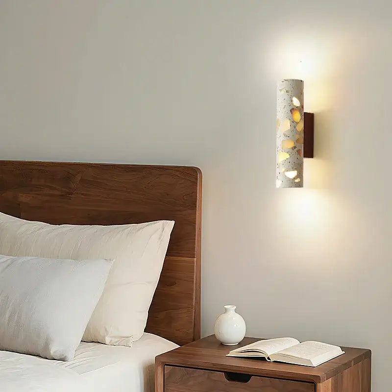 Modern terrazzo concrete led wall sconce with yellow and white pebbles mounted on a dark wood bracket decorbites led wall