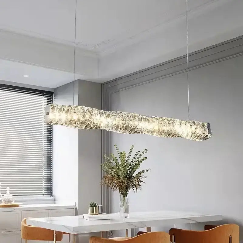 A modern elongated crystal led pendant light with textured translucent glass and warm illumination for dining rooms