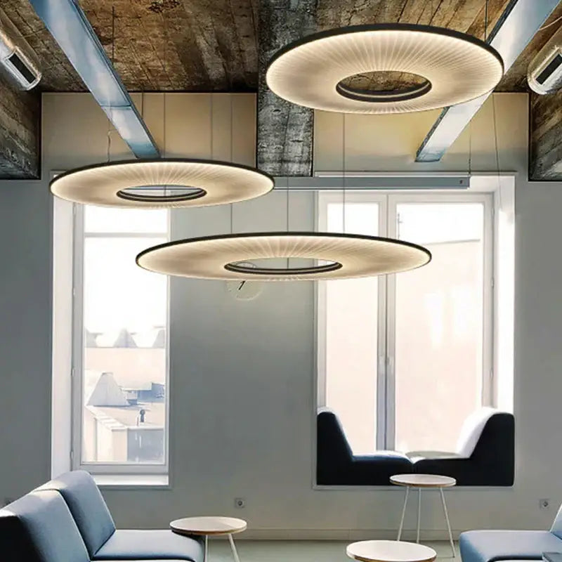 Three modern dix heures round fabric pendant lights with warm glow and black rims for dining room use