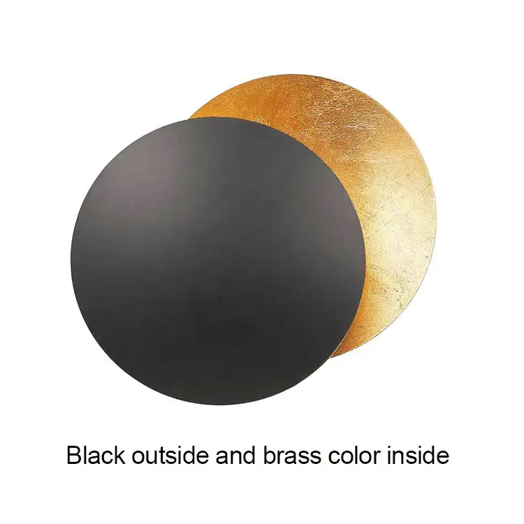 Black and brass modern textured eclipse round wall lamp with matte black exterior and gold textured interior for bedroom