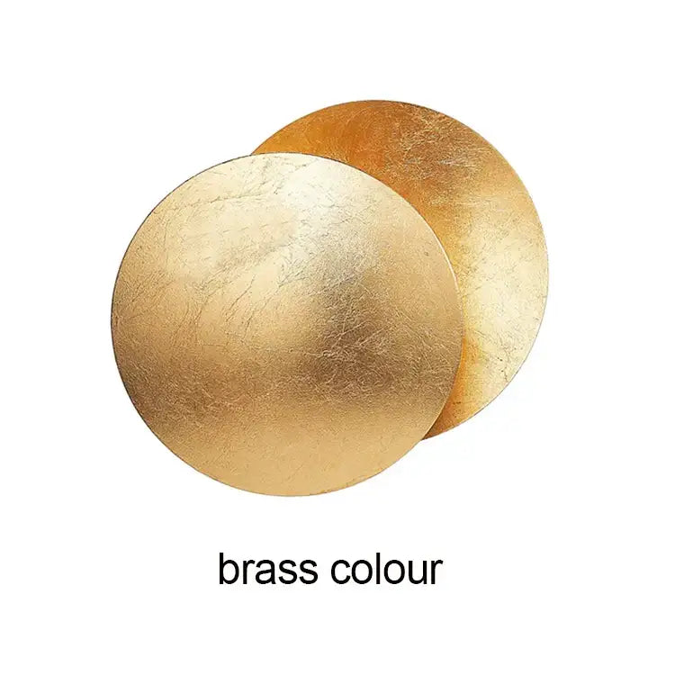 Modern textured eclipse round wall lamp featuring two overlapping brushed brass discs for bedroom lighting