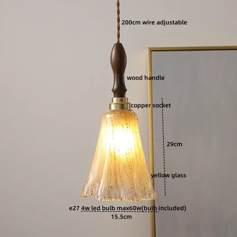 A warm amber glass copper led pendant light with textured fluted design and dark wood handle for kitchen dining room