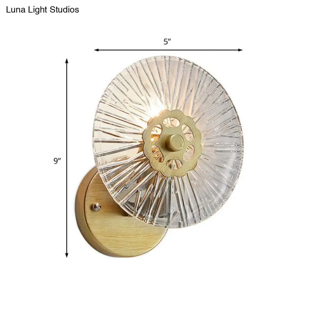 Modern textured gold wall lamp with clear crystal sconce, brass gear design, and wooden backplate for bedroom lighting