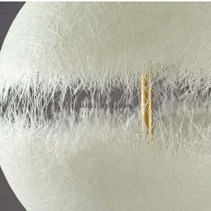 Modern textured moon pendant chandelier featuring a spherical white fiber optic lamp with a central gold-toned rod decorbites designer moon