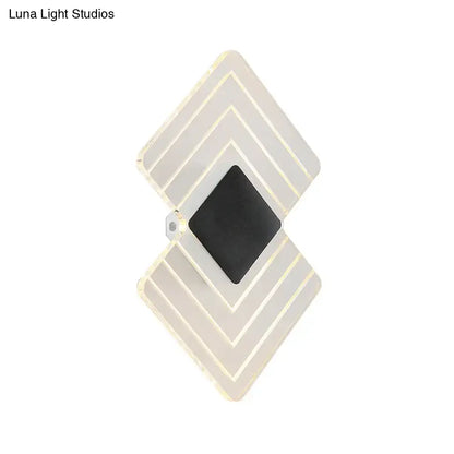 Modern textured silver and black direct wired electric led wall sconce with diamond-shaped layered translucent panels