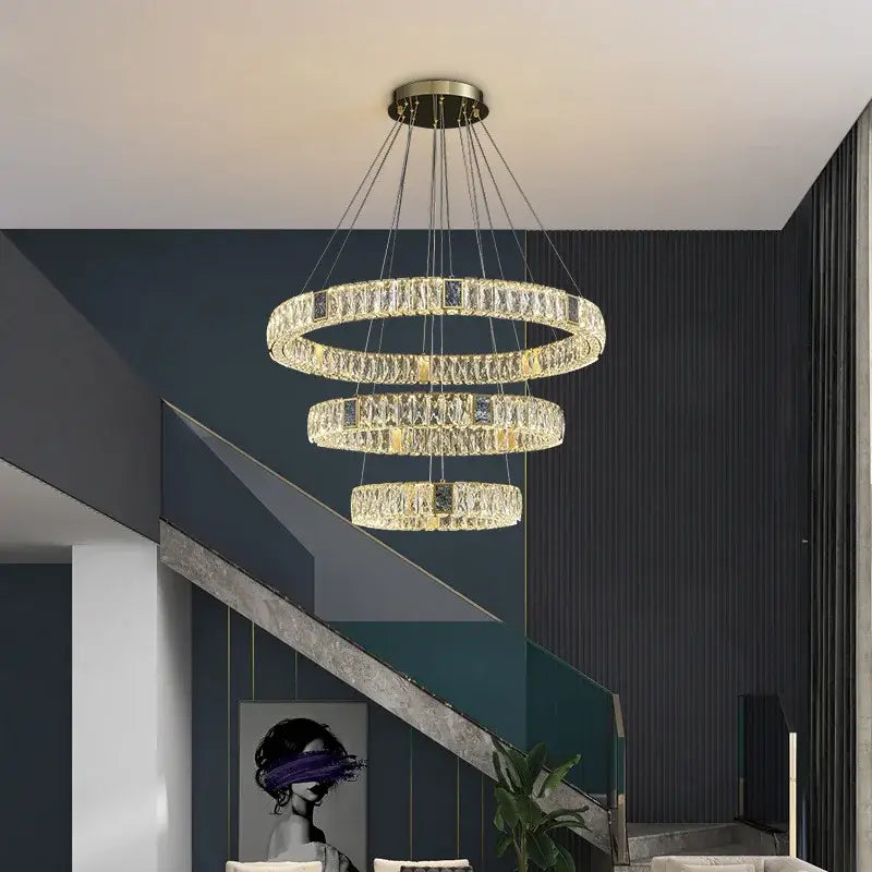 A modern three tier crystal golden led ring chandelier with gold-toned metal frame and hanging chains for dining room decorbites golden led