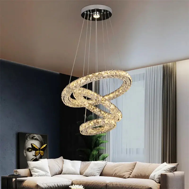 Modern three tier spiral crystal led chandelier pendant with intertwined rings and warm golden glow for dining room decorbites crystal led