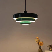 Modern tiered pendant light with dark green and black concentric rings emitting soft ambient light for dining room decorbites dark green