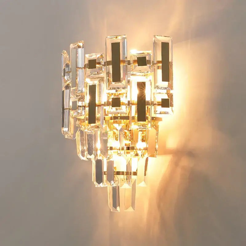 Modern tiered clear and dark crystal wall lamp with gold accents decorbites crystal wall lamp casting warm light